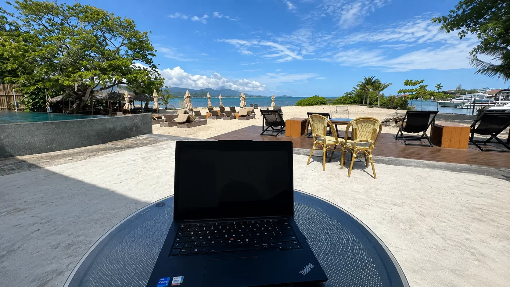 Arbeitsplatz am Strand von Ko Samui mit Blick auf Meer und Marina — arbeiten, wo andere Urlaub machen
