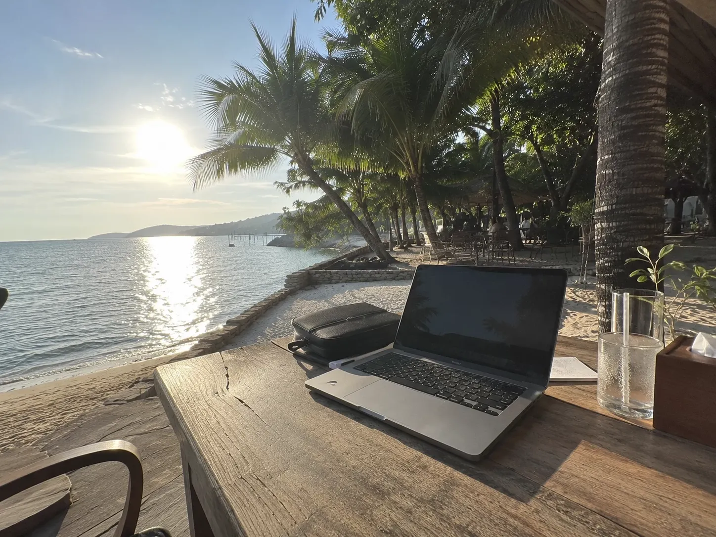 Laptop auf einem Holztisch am Strand von Ko Samui im Abendlicht — Raum für Reflexion